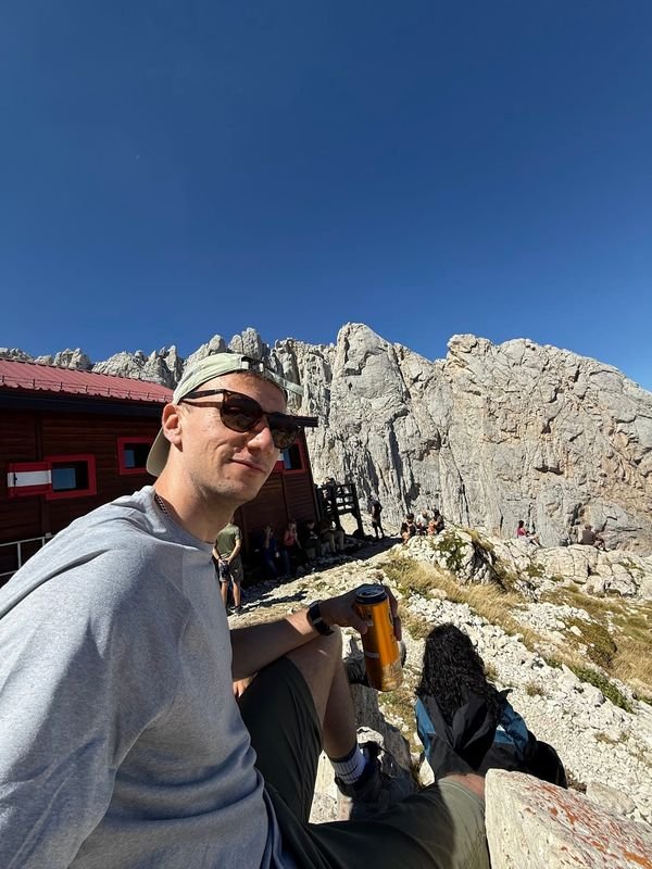 Giulio seduto davanti al Rifugio Franchetti, tra le pareti di roccia del Gran Sasso